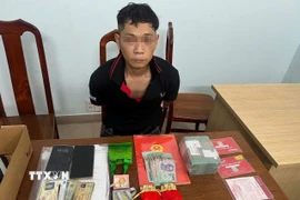 Đối tượng Đỗ Tấn Được cùng tang vật vụ án. (Ảnh: TTXVN phát)