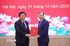 Giáo sư-Tiến sỹ Nguyễn Xuân Thắng, Ủy viên Bộ Chính trị, Bí thư Đảng ủy, Giám đốc Học viện Chính trị Quốc gia Hồ Chí Minh, Chủ tịch Hội đồng Lý luận Trung ương trao Quyết định cho ông Lê Hải Bình. (Ảnh: Văn Điệp/TTXVN)