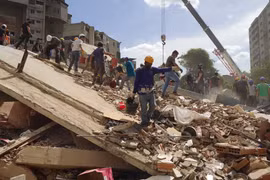 Các lực lượng cứu hộ Venezuela tìm kiếm những người mất tích và mắc kẹt dưới đống đổ nát. (Ảnh: Phi Hùng/TTXVN)