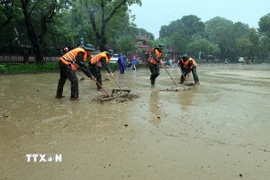 Lực lượng vũ trang dọn dẹp bùn, rác thải tại khu vực đường Lê Lợi ven bờ sông Hương, thành phố Huế khi nước lũ rút. (Ảnh: Đỗ Trưởng/TTXVN)