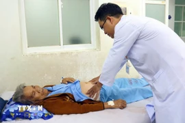 Bác sỹ của Bệnh viện Đa khoa Ninh Thuận (tỉnh Khánh Hòa) thăm, khám cho bệnh nhân Lâm Thị Đào tại khoa Hồi sức tích cực-Chống độc. (Ảnh: TTXVN phát)