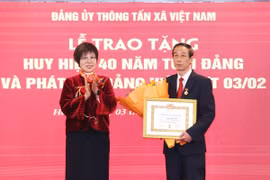 Bà Vũ Việt Trang, Ủy viên Ban Chấp hành Đảng bộ Khối các cơ quan Trung ương, Bí thư Đảng ủy, Tổng Giám đốc Thông tấn xã Việt Nam trao Huy hiệu 40 năm tuổi Đảng cho ông Thân Văn Hạnh. (Ảnh: Phương Hoa/TTXVN)
