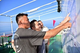 Cử tri tàu Hải An 68 tìm hiểu danh sách niêm yết các ứng viên đại biểu Quốc hội khóa XVI và đại biểu Hội đồng Nhân dân Thành phố Hồ Chí Minh nhiệm kỳ 2026-2031. (Ảnh: TTXVN phát)