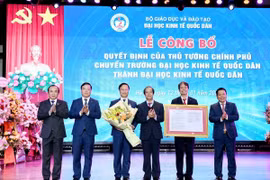 Bộ trưởng Bộ Giáo dục và Đào tạo Nguyễn Kim Sơn trao Quyết định cho lãnh đạo Đại học Kinh tế Quốc dân. (Ảnh: TTXVN phát)