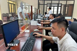Cán bộ Trung tâm phục vụ hành chính công xã Nam Cường (tỉnh Hưng Yên) thực hiện thủ tục hành chính cho người dân trong ngày đầu thực hiện mô hình chính quyền địa phương 2 cấp. (Ảnh: Thu Hoài/TTXVN)