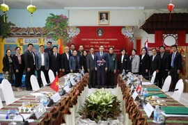 Đại sứ Phạm Việt Hùng (giữa) chụp ảnh lưu niệm với Ban lãnh đạo nhà trường cùng lãnh đạo Hội người Việt Nam tại Thái Lan và Hội người Việt Nam tỉnh Udon Thani. (Ảnh: TTXVN phát)