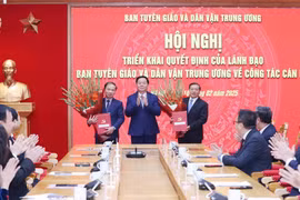 Ông Nguyễn Trọng Nghĩa, Ủy viên Bộ Chính trị, Bí thư Trung ương Đảng, Trưởng Ban Tuyên giáo và Dân vận Trung ương trao quyết định tham gia Ban Thường vụ Đảng uỷ các cơ quan Đảng Trung ương cho hai Phó Trưởng Ban Lại Xuân Môn và Phạm Tất Thắng. (Ảnh: Phương Hoa/TTXVN)