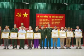 Đại tá Đinh Xuân Hướng, Phó Chủ nhiệm Chính trị Quân khu 4 và Đại tá Trương Như Ý, Phó Chính ủy Bộ Chỉ huy Quân sự tỉnh Quảng Trị thừa ủy quyền của Thủ tướng trao Bằng "Tổ quốc ghi công" cho thân nhân các gia đình liệt sỹ. (Ảnh: Nguyên Linh/TTXVN)