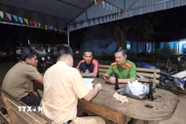 Lực lượng Cảnh sát giao thông lập biên bản xử lý các đối tượng dàn hàng ngang, bốc đầu xe máy trên đường vành đai Trảng cỏ Bù Lạch. (Ảnh: TTXVN phát)