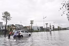 Có người phải đẩy xe ôtô do chết máy giữa đường vì ngập nước. (Ảnh: Thanh Vân/TTXVN)