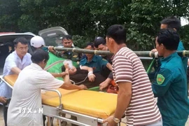 Sản phụ được khiêng từ vùng cô lập đến cơ sở y tế. (Ảnh: TTXVN phát)