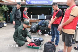 59 đối tượng và tang vật vụ án lừa đảo qua mạng hơn 300 tỷ đồng bị bắt tại Campuchia. (Ảnh: TTXVN phát)