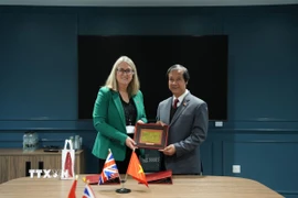 Bộ trưởng Nguyễn Kim Sơn và Thứ trưởng Jacqui Smith trao quà lưu niệm. (Ảnh: TTXVN phát)