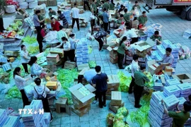 Cán bộ, chiến sỹ gấp rút chia các suất quà để kịp thời gửi đến người dân vùng lũ ở Huế. (Ảnh: Văn Dũng/TTXVN)