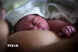 Bé sơ sinh bú sữa mẹ tại bệnh viện ở Ygos-Saint-Saturnin, Pháp. (Ảnh: AFP/TTXVN)