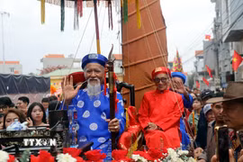 Cụ ông Vũ Văn Oanh (hàng đầu áo xanh), phường Phong Cốc, tỉnh Quảng Ninh, tròn 80 tuổi và được con cháu rước lên miếu Tiên Công. (Ảnh: Đức Hiếu/TTXVN)