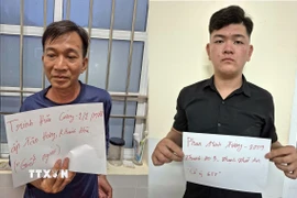 Hai đối tượng Trịnh Hữu Cường và Phan Minh Tường tại cơ quan công an. (Ảnh: TTXVN phát)