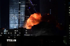 Khói lửa bốc lên từ tòa nhà bị trúng tên lửa của Iran tại Tel Aviv, Israel tối 14/6/2025. (Ảnh: THX/TTXVN)