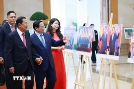 Thủ tướng Phạm Minh Chính và Chủ tịch Đảng Nhân dân Campuchia, Chủ tịch Thượng viện Campuchia Hun Sen tham quan trưng bày ảnh về quan hệ hợp tác giữa hai nước do TTXVN thực hiện. (Ảnh: Dương Giang/TTXVN)