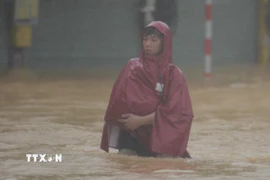 Người dân di chuyển khó khăn tại khu vực nước sâu. (Ảnh: Văn Dũng/TTXVN)