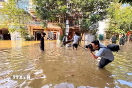 Phóng viên Nguyễn Quang Cường của Thông tấn xã Việt Nam tác nghiệp tại thời điểm cơn bão số 10 năm 2025 gây ảnh hưởng. (Ảnh: TTXVN)