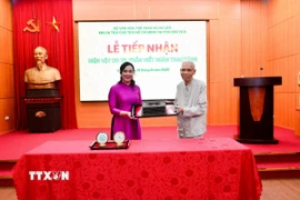 Ông Trần Viết Hoàn - cận vệ của Bác Hồ, nguyên Giám đốc Khu Di tích Chủ tịch Hồ Chí Minh tại Phủ Chủ tịch trao tặng hiện vật chiếc máy chữ cho Khu Di tích. (Ảnh: TTXVN phát)