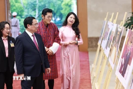 Thủ tướng Phạm Minh Chính và Quốc vương Bhutan Jigme Khesar Namgyel Wangchuck tham quan trưng bày ảnh về quan hệ hợp tác giữa hai nước do Thông tấn xã Việt Nam thực hiện. (Ảnh: Dương Giang/TTXVN)