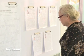 Tại các khu vực bỏ phiếu, lý lịch trích ngang của các ứng viên đều được niêm yết công khai, tiện cho cử tri nghiên cứu trước khi đưa ra quyết định cho lá phiếu của mình. (Ảnh: Hữu Duyên/Vietnam+)