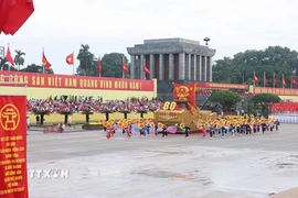 Xe mô hình Quốc huy nước Cộng hòa xã hội chủ nghĩa Việt Nam đi đầu khối diễu binh, diễu hành. (Ảnh: TTXVN)