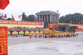 Xe mô hình Quốc huy nước Cộng hòa xã hội chủ nghĩa Việt Nam đi đầu khối diễu binh, diễu hành. (Ảnh: TTXVN)