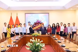 Phó Trưởng ban Thường trực Ban Tuyên giáo và Dân vận Trung ương Lại Xuân Môn tặng hoa chúc mừng những người làm báo của TTXVN. (Ảnh: Minh Đức/TTXVN)