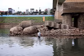 Mực nước hạ du sông Đà xuống thấp đến mức người dân có thể lội qua sông. (Ảnh: Thanh Hải/TTXVN)