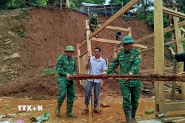 Chiến sỹ Đồn biên phòng Mỹ Lý giúp người dân địa phương khắc phục hậu quả mưa lũ. (Ảnh: TTXVN phát)