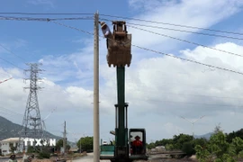 Lắp đặt hệ thống điện phục vụ thi công dự án đường nối Quốc lộ 1 đến Cảng biển tổng hợp Cà Ná. (Ảnh: Công Thử/TTXVN)