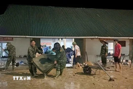 Các lực lượng chức năng triển khai hỗ trợ dọn dẹp và đưa học sinh đến nơi an toàn. (Ảnh: TTXVN phát)