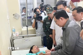 Thay mặt Chính phủ, Phó Thủ tướng Hồ Quốc Dũng tặng quà động viên nạn nhân vụ trong vụ sạt lở đèo Khánh Lê. (Ảnh: Phan Sáu/TTXVN)