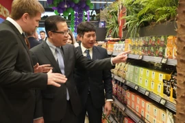 Đại sứ Đặng Minh Khôi (giữa) đi thăm các kệ trưng bày hàng Việt Nam. (Ảnh: Quang Vinh/TTXVN)