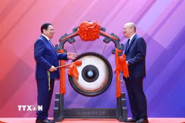 Thủ tướng Phạm Minh Chính thực hiện nghi thức đánh cồng tại Sàn giao dịch chứng khoán Thượng Hải. (Ảnh: Dương Giang/TTXVN)