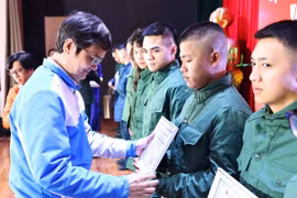 Bí thư thứ Nhất Trung ương Đoàn Bùi Quang Huy trao giấy chứng nhận và quà tặng cho các thanh niên tình nguyện lên đường nhập ngũ bảo vệ Tổ quốc. (Ảnh: Minh Đức/TTXVN)