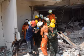 Lực lượng cứu hộ của Việt Nam, Myanmar và Thổ Nhĩ Kỳ đưa nạn nhân ra xe cứu thương. (Ảnh: Vũ Hùng/TTXVN phát)