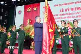 Tổng Bí thư Tô Lâm gắn Danh hiệu Anh hùng Lực lượng Vũ trang Nhân dân lên Quân kỳ Quyết thắng của Tổng cục Công nghiệp Quốc phòng. (Ảnh: Trọng Đức/TTXVN)