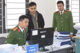 Lực lượng chức năng khám xét nơi làm việc của Vũ Tuấn Anh. (Ảnh do công an cung cấp)