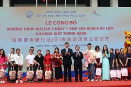 Tặng quà lưu niệm cho khách du lịch hai nước. (Ảnh: Quang Duy/TTXVN)