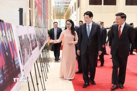 Chủ tịch nước Lương Cường và Tổng Bí thư, Chủ tịch nước Lào Thongloun Sisoulith tham quan trưng bày ảnh quan hệ hữu nghị hai nước do Thông tấn xã Việt Nam thực hiện. (Ảnh: Lâm Khánh/TTXVN)