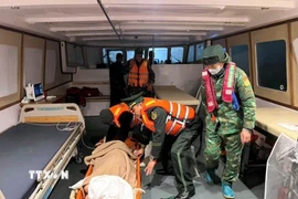 Biên phòng Quảng Ninh hỗ trợ đưa bà Kosuge Kimiko (sinh năm 1949, quốc tịch Nhật Bản) bị đột quỵ vào bờ an toàn để cấp cứu. (Ảnh: TTXVN phát)