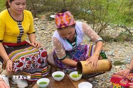 Nước “chè đâm” được giã nhuyễn bằng ống mét già rồi đổ ra bát sứ trước khi thưởng thức. (Ảnh: TTXVN phát)