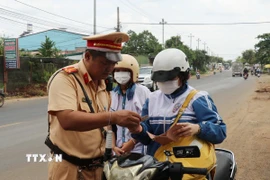 Lực lượng chức năng tuần tra kiểm soát giao thông kết hợp với tuyên truyền nhắc nhở học sinh tham gia giao thông đảm bảo các quy định của pháp luật. (Ảnh: Tuấn Anh/TTXVN)