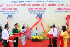 Các đại biểu thực hiện nghi thức đặt tên đường Phan Văn Khải, đoạn Quốc lộ 22 từ cầu An Hạ đến ranh giới tỉnh Tây Ninh. (Ảnh: Tiến Lực/TTXVN)