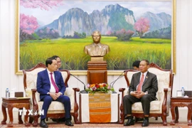 Đại tướng Vilay Lakhamfong, Ủy viên Bộ Chính trị, Thường trực Ban Bí thư (phải) tiếp Thượng tướng Lê Quốc Hùng, Ủy viên Trung ương Đảng, Thứ trưởng Bộ Công an Việt Nam sang chúc mừng. (Ảnh: Xuân Tú/TTXVN)