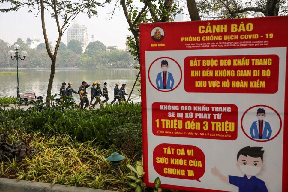 Tại đây có quy định bắt buộc đeo khẩu trang khi đến không gian khu vực phố đi bộ, ghi rõ mức xử phạt từ 1-3 triệu đồng với những cá nhân vi phạm. Phớt lờ với những biển khuyến cáo đó, nhiều người vẫn không đeo khẩu trang. (Ảnh: Minh Sơn/Vietnam+)